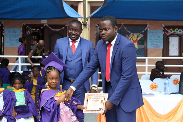 Chief Director of the school presenting a certificate to a pupil