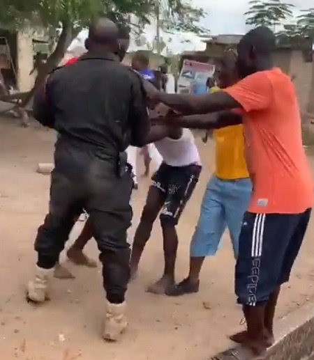 A police officer being attacked by some residents of Amasaman in Accra