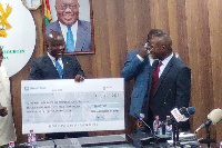 Minister for Lands and Natural Resources, Samuel A. Jinapor with the cheque