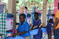 Pupils washing their hands under running water