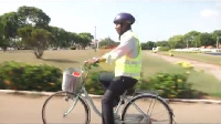 Hon. Ras Mubarak rides on a bicycle to Parliament