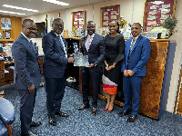 Ernest Addison being presented with a plaque