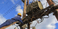 A Kenya Power technician working on a step-down transformer