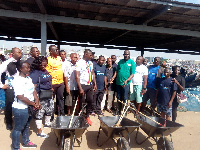 Official of EPA presenting wheel barrows, rakes, shovels and brooms to Tema Fishing Harbour