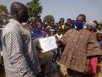 Moses Jotie, Wa East DCE, handing over the award to the best farmer