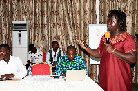 Dr Efua Commeh speaking at a stakeholders meeting for PLWNCDs