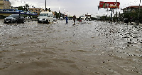 Cars drive along a flooded street in Khartoum after torrential rain fell on the Sudanese capital