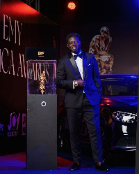 Ghanaian actor, Bill Asamoah displays the award he won at the event