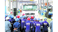 Vehicle Assembly Limited workers admire a new truck upon completing assembling it at the factory