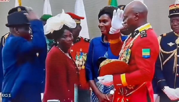 General Oligui Nguema salutes his father as mother and wife look on