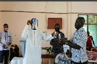 Kwasi Bonzoh presenting items to one of the Senior High Schools