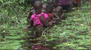 Children crossing the stream to the next village