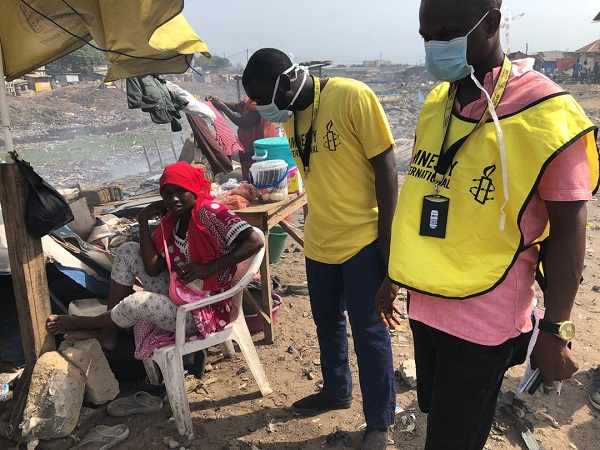 President of Amnesty International, Robert Akoto(middle) interacting with an affected resident