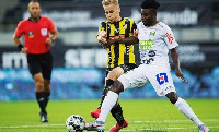 Gideon Mensah (in white jersey) battles with his opponent to keep possession of the ball