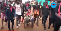 The chief being pulled in a wheelchair