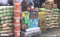 Items presented include bags of rice, soft drinks, medical supplies, washing powders