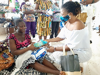 Ms Gifty Atampugbire (right) presenting some of the items to a mother