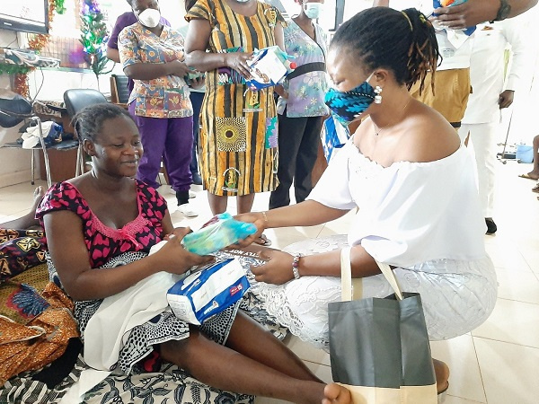 Ms Gifty Atampugbire (right) presenting some of the items to a mother