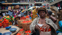 A woman selling tomatoes in a market