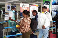 An official screens travellers arriving at Entebbe International Airport in Uganda