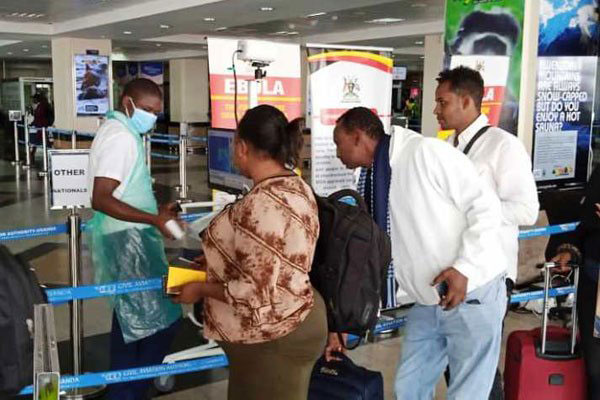 An official screens travellers arriving at Entebbe International Airport in Uganda