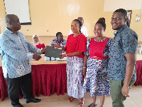 James Affadu presenting a laptop to some GNAT executives