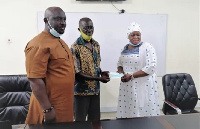 Ashanti Regional Manager of MASLOC, Hagia Zainab Sallow, presenting a cheque to one of the poultry f