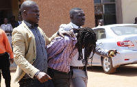 Gregory Afoko in a police grip