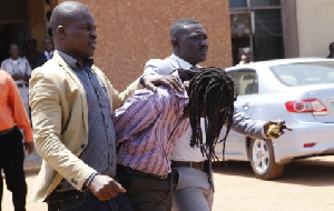 Gregory Afoko in police grip