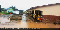 Pupils on the corridor of the school block waiting to cross to another side of the compound