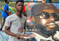 Oscar Korbla Mawuli Awuku standing close to one of his works