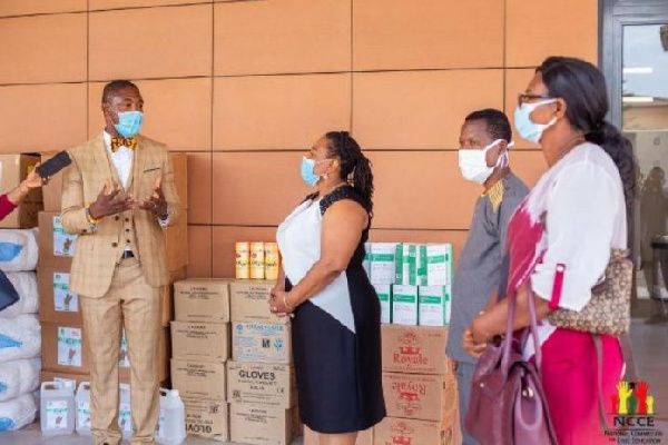 Ms Nkrumah receiving the PPE from Dr Bernard Okoe-Boye