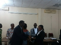 A female referee receiving her FIFA badges at the GFA Secretariat