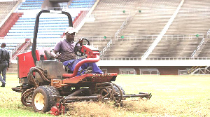 The matted turf on the field being worked on to help with drainage at the National Sports Stadium