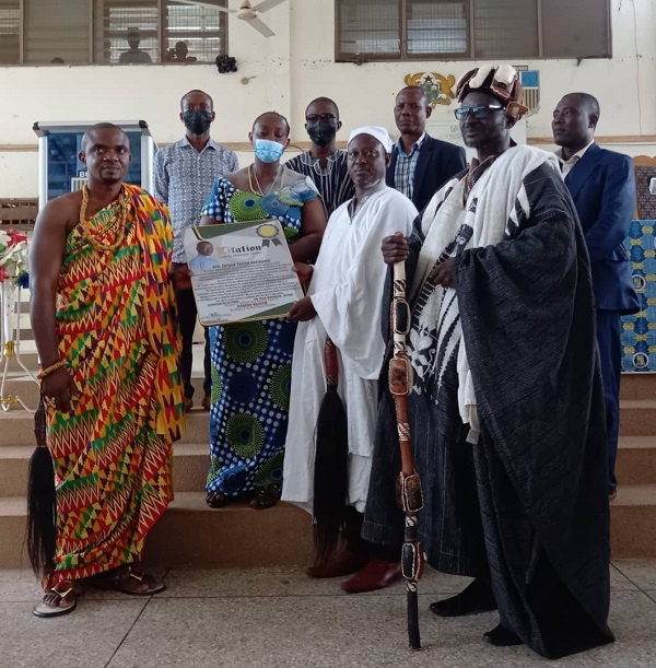 Headmaster of the Bueman SHS in a group picture with his citation