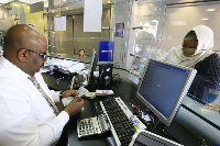 A woman is served at a currency exchange firm in Khartoum. PHOTO | FILE | NATION MEDIA GROUP