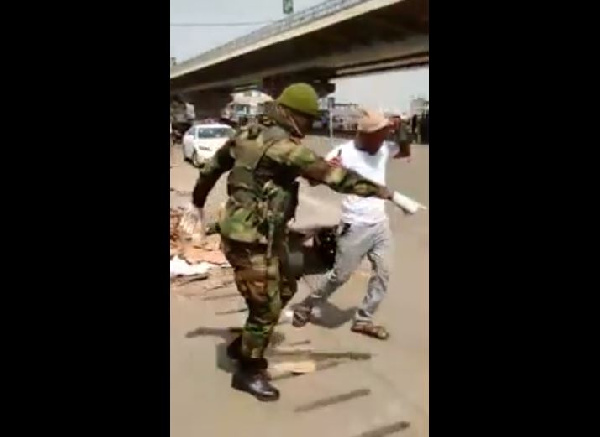 A shot of a soldier instructing a civilian to undertake frog jumps