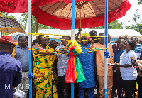 George Mireku Duker assisted by the chief to cut the ribbon for the project