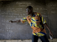 A teacher writing on the black board