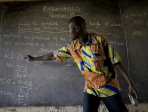 A teacher writing on the black board