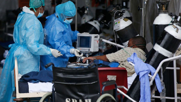 Medical staff wearing protective gear with a patient infected with the COVID-19 - File