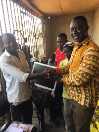 Dr Godfred Jasaw presenting the items to the school