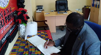 President of the Local Organizing Committee, Dr. Kwaku Ofosu-Asare signing the book of condolence