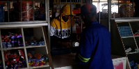 A shopkeeper serves a customer during an electricity load-shedding blackout in Hillcrest