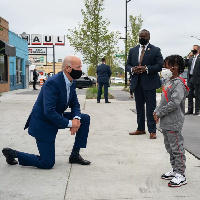 US Presidential Candidate, Joe Biden, kneeling in front of a young boy