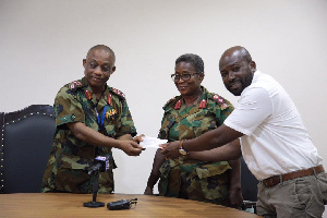 Mr. Hosi handing the cheque over to Brigadier General Nii Adjah Obodai