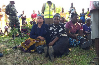 Sanitation minister Gladys Ganda (L) waits with govt official Abide Mia (R) for update on rescues