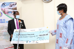 Pastor Dr. Thomas Techie Ocran presenting the cheque to Madam Sophia Akufo