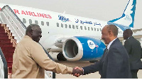 Sudanese Army Chief General Abdel Fattah al-Burhan (R) shakes hands with an official