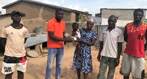 Mercy Nabarise receiving the donation in the presence of her family